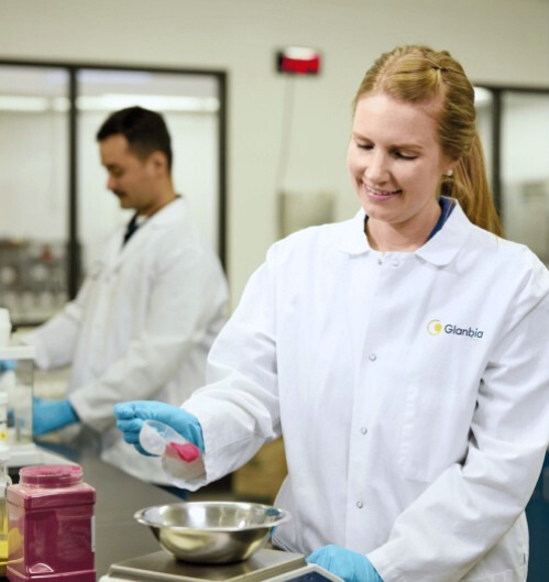 woman working in a lab scooping ingredients