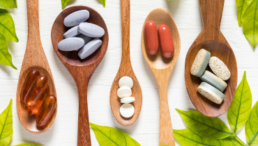 four wooden spoons with different supplements on each one