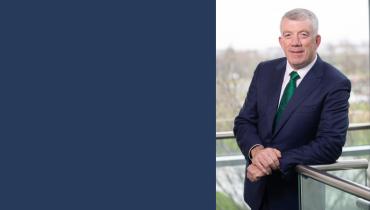 Hugh McGuire in a suit leaning on a barrier