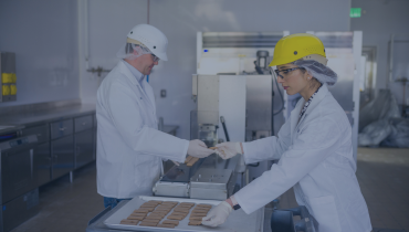 two people working in a lab with hardhats on