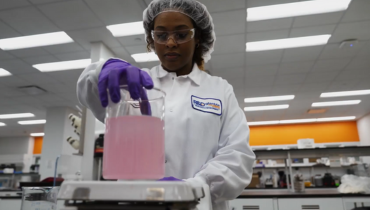 woman working with pink liquid in a lab 