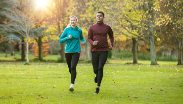 a man and a woman running in a park