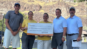 group of people holding a cheque for $329,000