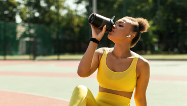 girl sitting on ground drinking healthy drink