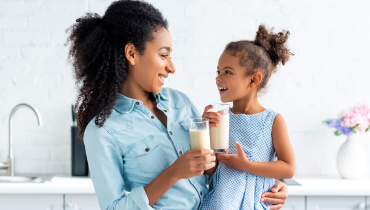 woman and child both holding glasses of milk
