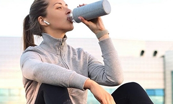 a girl drinking from a flask