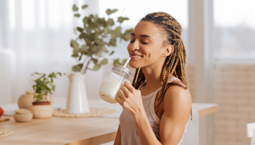 woman smiling drinking milk from a jar