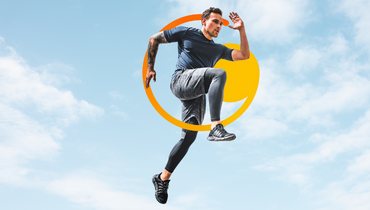 Man in running pose with blue skies behind him