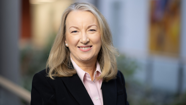 woman in suit smiling with blurred background