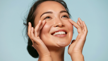 woman smiling looking up with her hands on her face