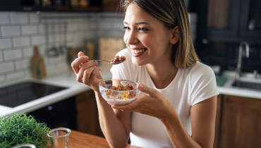 woman eating breakfast while smiling