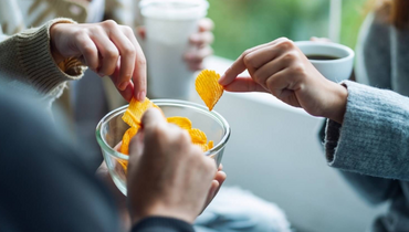 hands taking snacks from a bowl