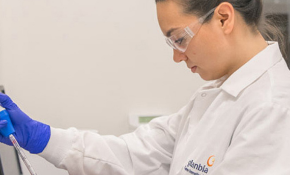 a woman wearing a white lap coat working