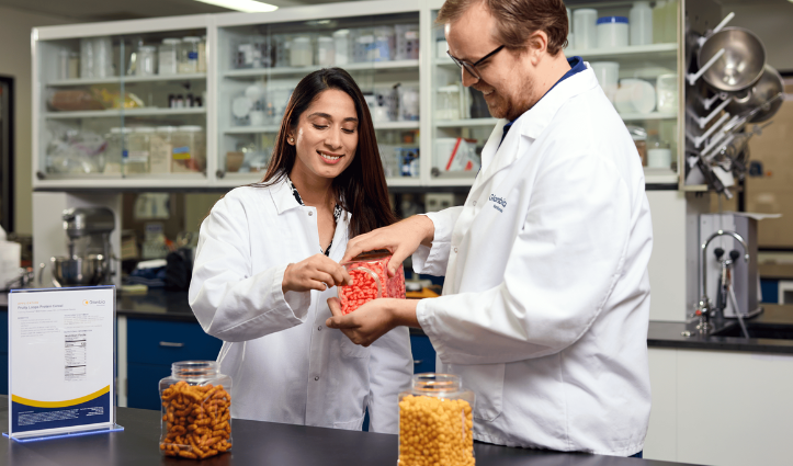 man and woman pouring protein ingredients out of a container