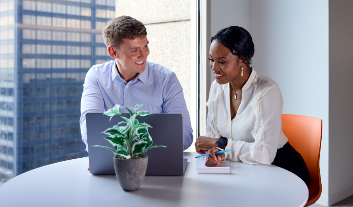 man and woman sitting at a desk with laptop