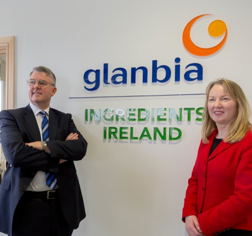 two people standing in front of a glanbia ingredients Ireland sign