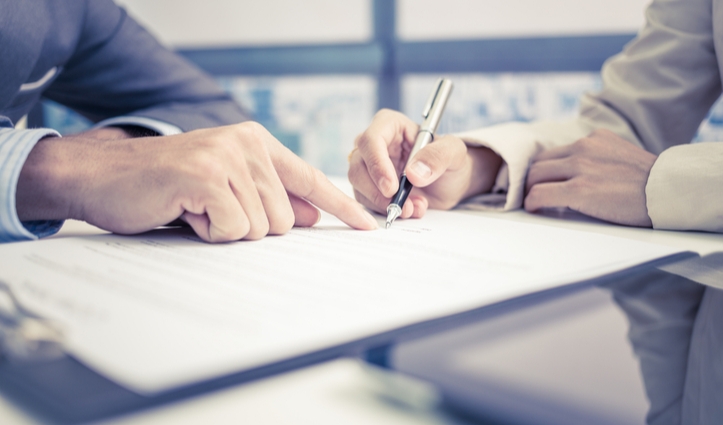hand pointing to a document while it's getting signed