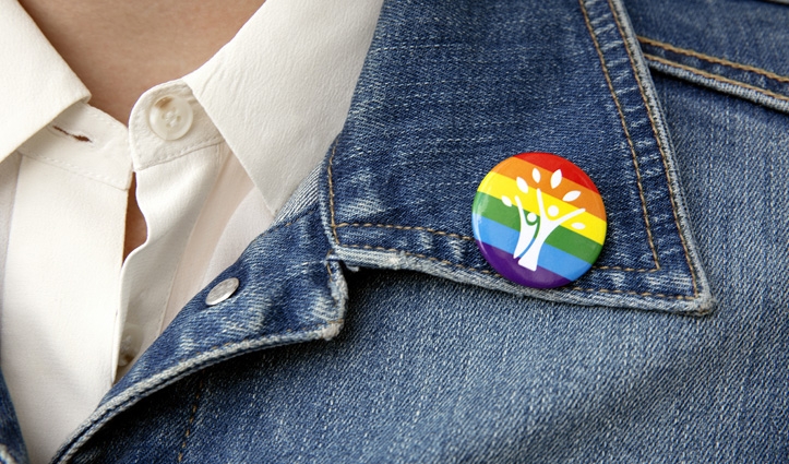 a denim jacket with a pride badge