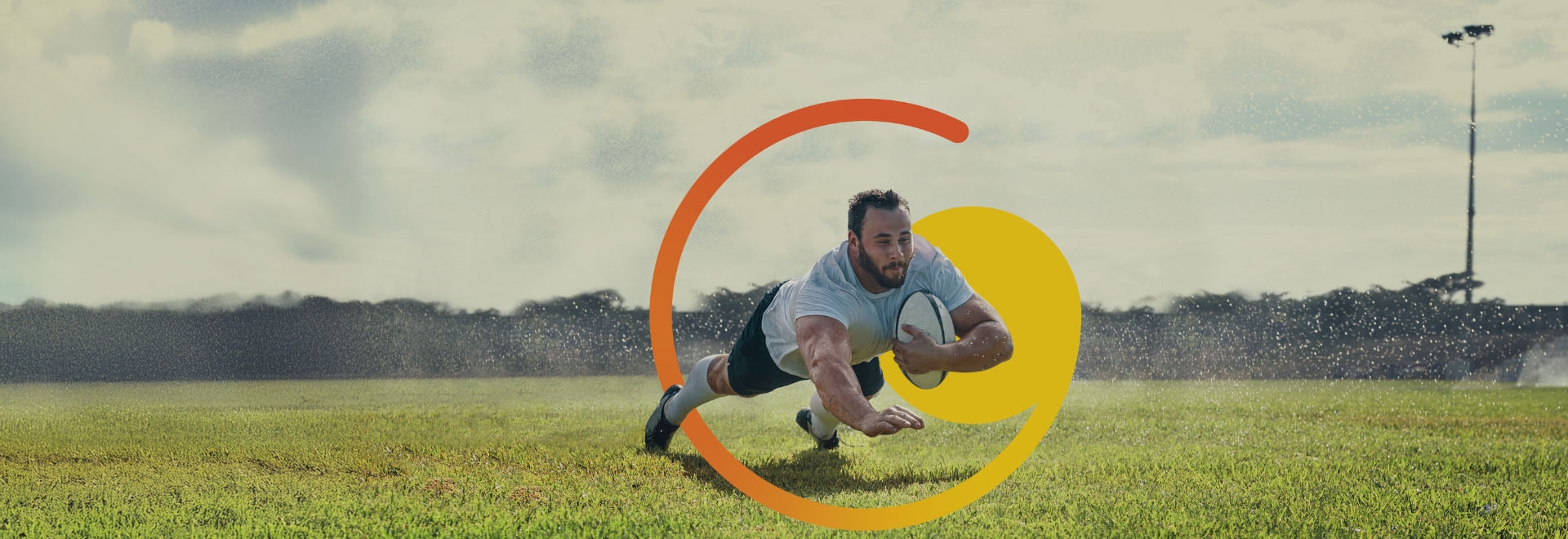 rugby player diving with ball on grassy field, orange-yellow graphic overlay