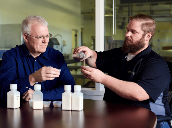 two men pouring liquid into cups