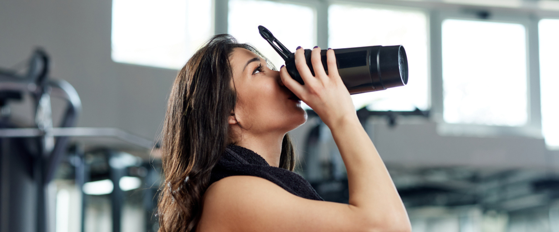 woman in gym drinking protein drink