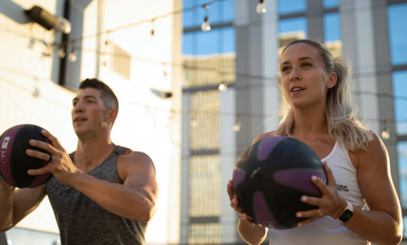 Man and woman holding fitness balls