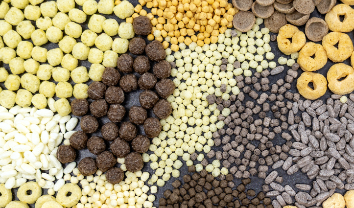 Assorted dry food pieces in various shapes and colours arranged in clusters