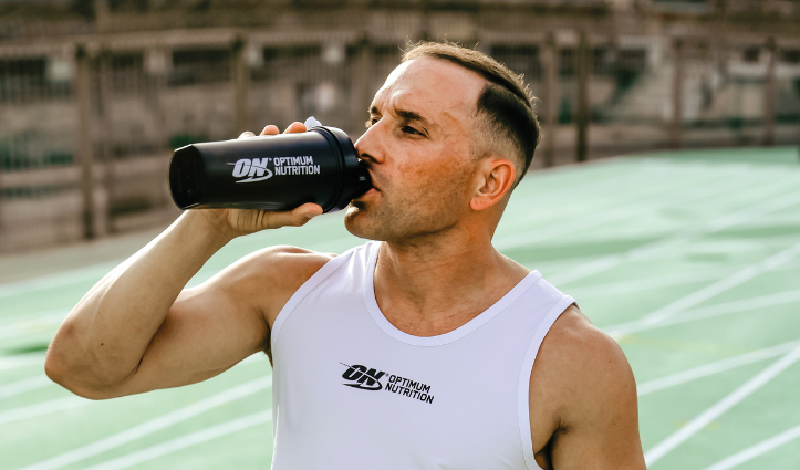 Man drinking out of an optimum nutrition bottle