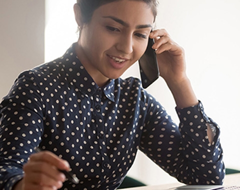 woman wearing polka dot shirt on a phone call