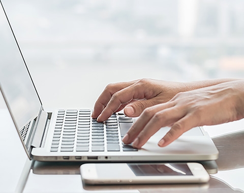 a person typing on a laptop keyboard