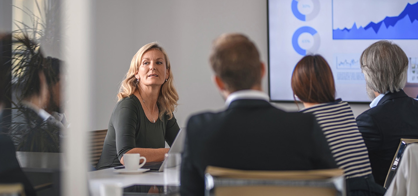 a group of people sitting around a table looking at a presentation