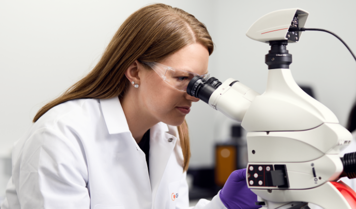 woman looking into a microscope