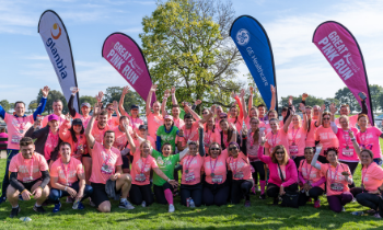 group of people wearing pink breast cancer awareness t-shirts cheering