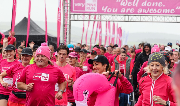 group of people all wearing pink running
