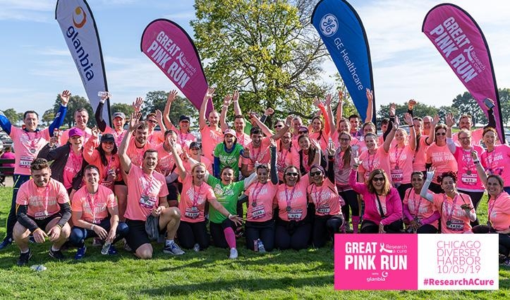 group of people wearing pink breast cancer awareness t-shirts cheering
