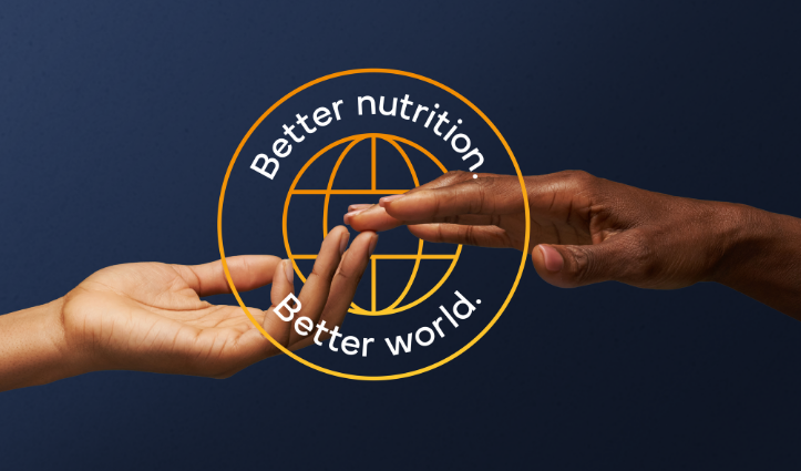 two hands touching with better nutrition, better world text