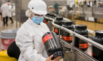 person in factory checking food labels on protein tubs