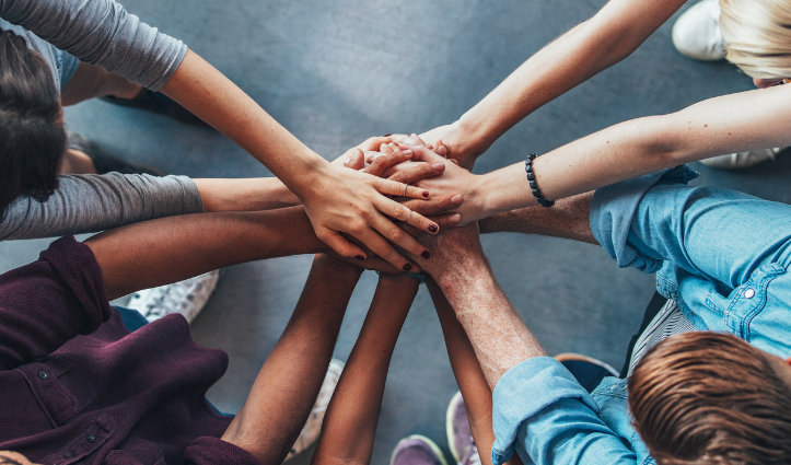 group of people all with their hands together