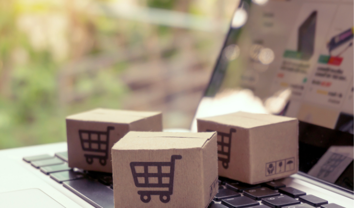 3 cardboard boxes with shopping cart icons on them on top of a laptop
