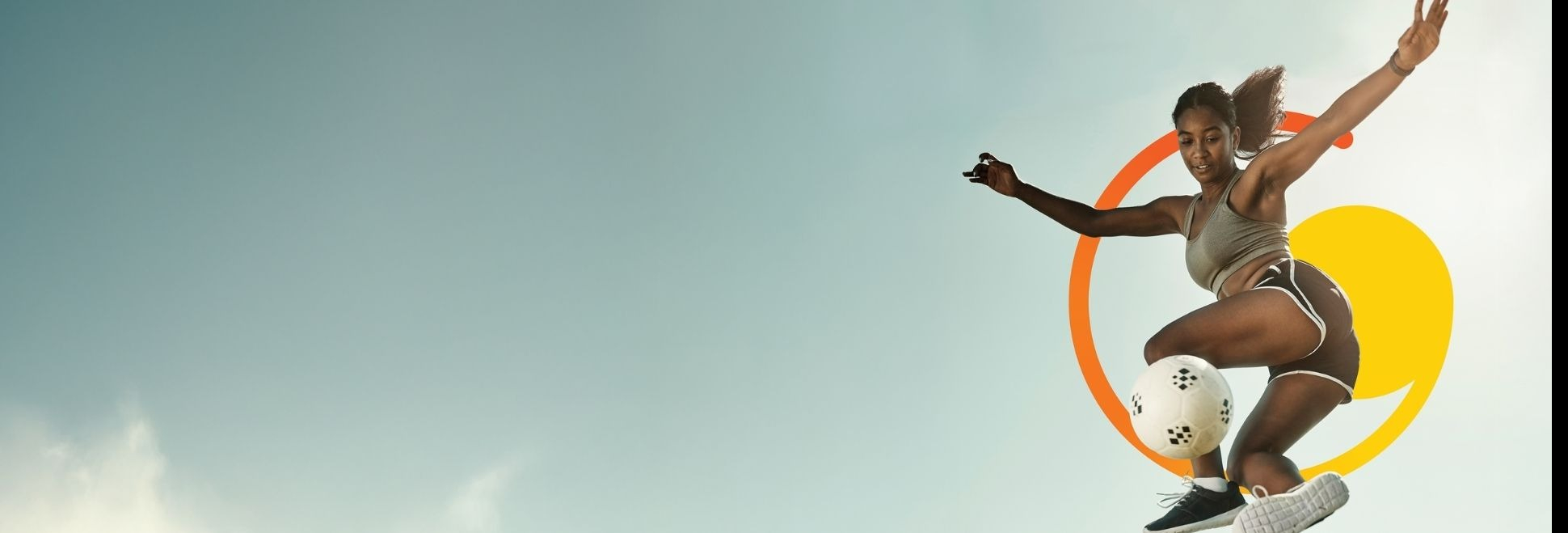 A person performing a mid-air soccer kick against a clear sky with colorful graphic elements behind them.