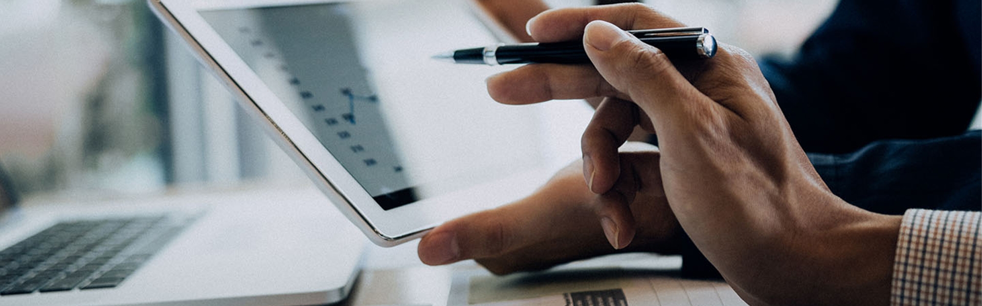 two men holding a tablet and pointing to the screen