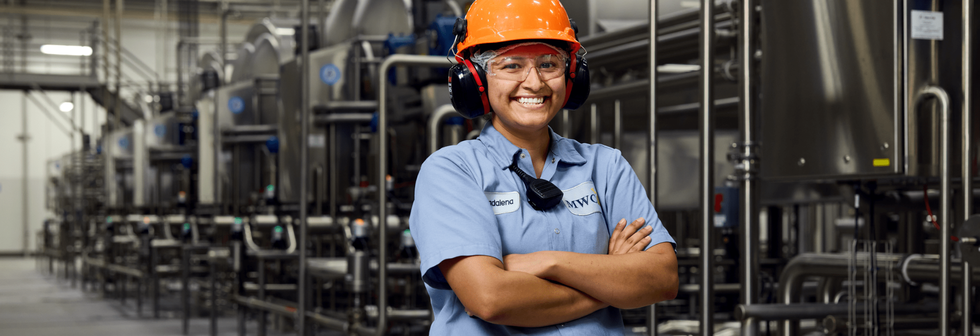 woman in a manufacturing facility with orange hat
