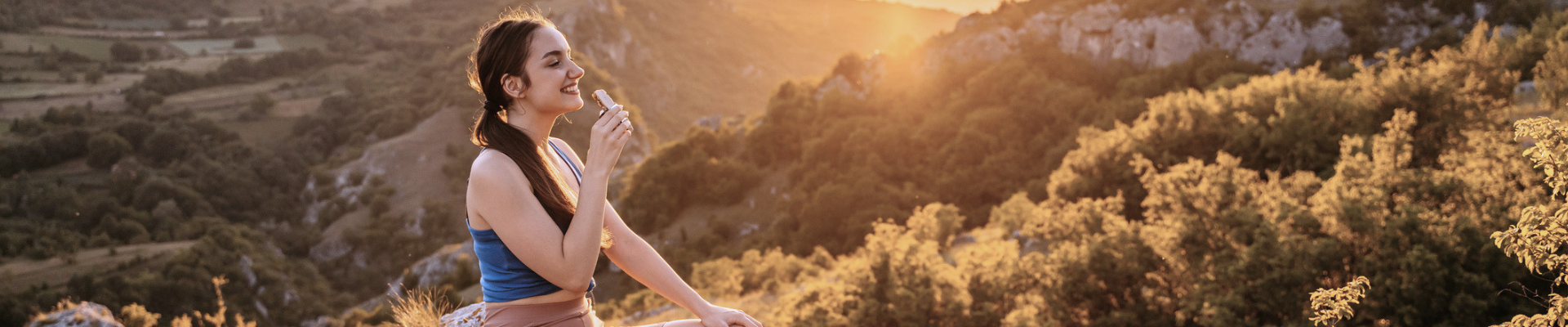 girl eating protein bar on a hike