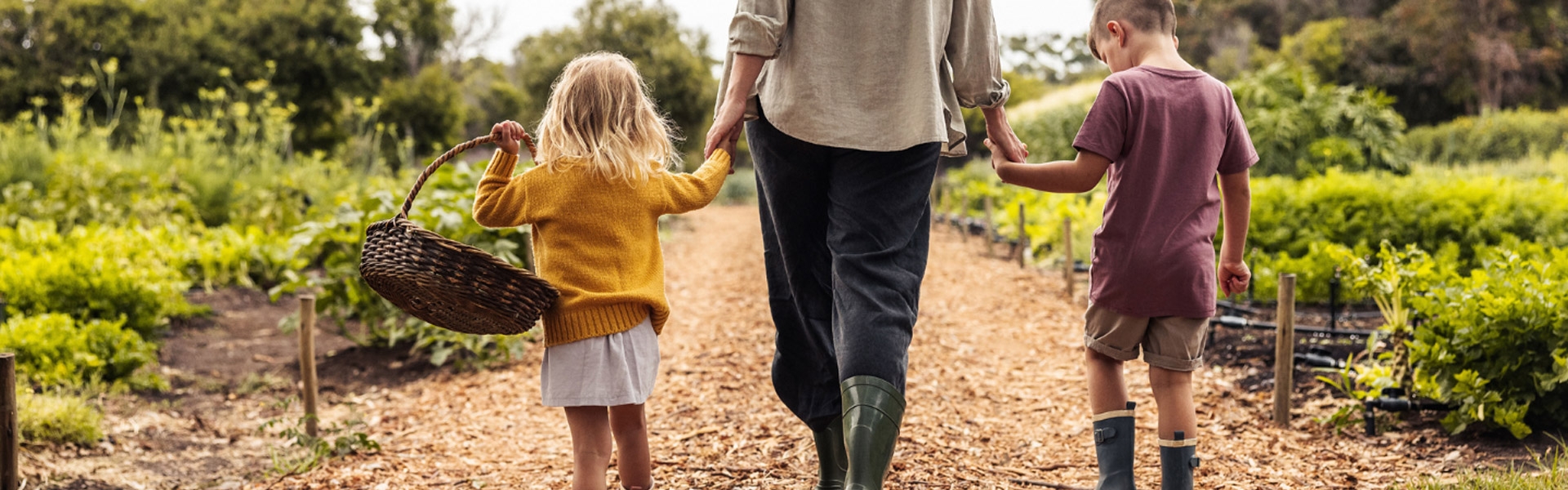 Adult and children walking holding hands walking down a trail